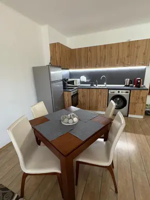 a kitchen with a wooden table and white chairs at Pine forest apartments in Pamporovo