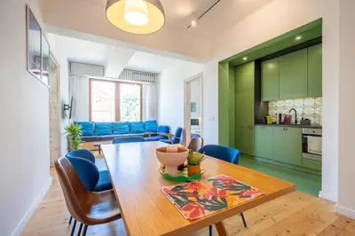 a kitchen and dining room with a table and blue chairs at Bright & Central 2BR in Historic Heart of Sofia in Sofia