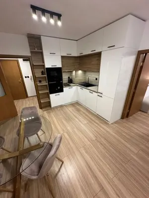 a kitchen with white cabinets and a glass table and chairs at K&D Alpine Getaway , Cozy Stay in Bansko