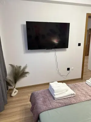 a room with a flat screen tv on a wall at K&D Alpine Getaway , Cozy Stay in Bansko
