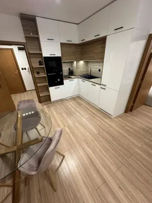 a kitchen with white cabinets and a glass table and chair at K&D Alpine Getaway , Cozy Stay in Bansko