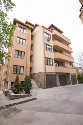a tall building with a garage in front of it at В Сандански есента идва с топлина, слънце и златна светлина in Sandanski