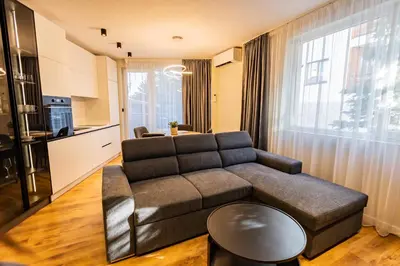 a living room with a couch and a table at Alpine Escape Design apartment Detelina Residence in Bansko