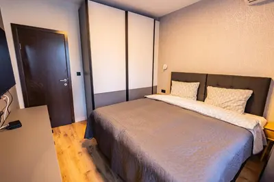a bedroom with a large bed and a door at Alpine Escape Design apartment Detelina Residence in Bansko