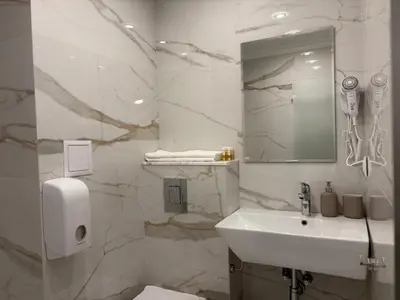 a white bathroom with a sink and a mirror at Hotel Odrys in Plovdiv