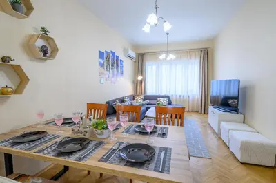 a dining room and living room with a table and chairs at Two Luxury Condos by NDK and National Stadium with 2 Free Parking Spots in Sofia
