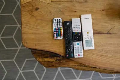 four remote controls sitting on top of a wooden table at Two Luxury Condos by NDK and National Stadium with 2 Free Parking Spots in Sofia