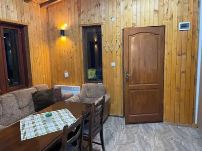 a living room with a table and a wooden wall at Studio Elias in Zlatograd