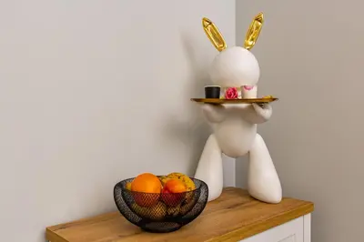a bunny with a plate on its head next to a bowl of fruit at Central Apartments with Garden view by Flat Mаnager in Plovdiv