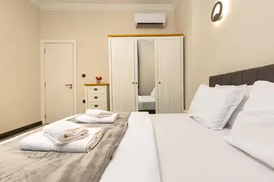 a bedroom with a white bed with towels on it at Central Apartments with Garden view by Flat Mаnager in Plovdiv