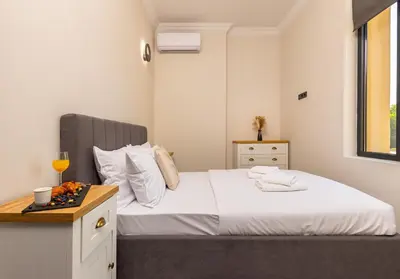 a bedroom with a bed and a table with a glass of wine at Central Apartments with Garden view by Flat Mаnager in Plovdiv