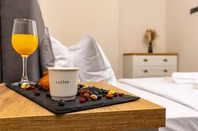 a table with a glass of orange juice and fruit at Central Apartments with Garden view by Flat Mаnager in Plovdiv