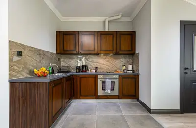 a kitchen with wooden cabinets and a counter top at Central Apartments with Garden view by Flat Mаnager in Plovdiv