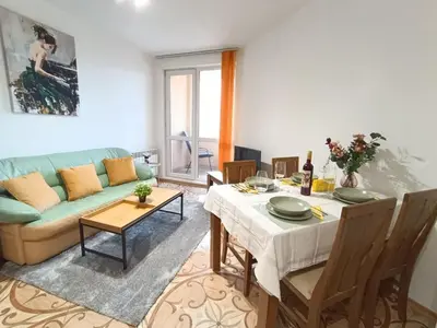 a living room with a table and a couch at Mladost the City of Fountains Vitosha View in Sofia