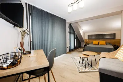 a room with a bed and a couch and a table at Вила Тих кът in Resilovo