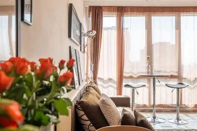 a living room with a couch and some red roses at Cozy Studio in Sofia