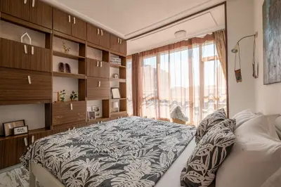 a bedroom with a bed and a large window at Cozy Studio in Sofia