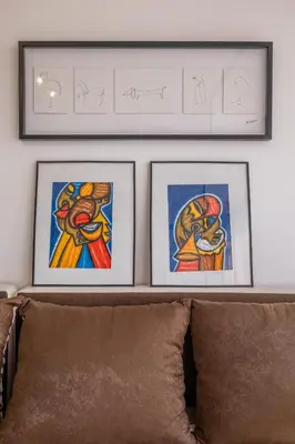 two framed pictures on a wall above a couch at Cozy Studio in Sofia
