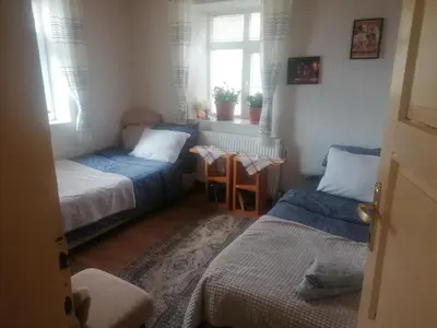 a small room with two beds and a window at Къща Сливови in Bŭnzareto