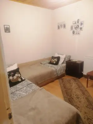 a room with two beds and a table in it at Къща Сливови in Bŭnzareto