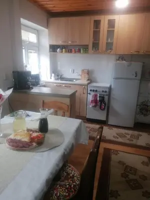 a kitchen with a table with a plate of food on it at Къща Сливови in Bŭnzareto