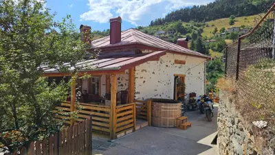 a small house with a barrel in front of it at Къща Сливови in Bŭnzareto