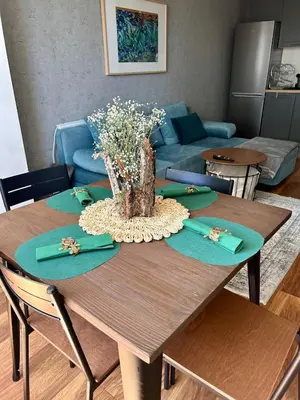 a table with green napkins and a vase of flowers on it at Cozy&Quiet l 1BD l Free Parking in Sofia