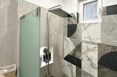 a bathroom with a shower with a glass door at Blue Breeze Apartment by Flat Mаnager in Sofia