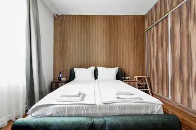 a bedroom with a large bed with a green bench at Blue Breeze Apartment by Flat Mаnager in Sofia