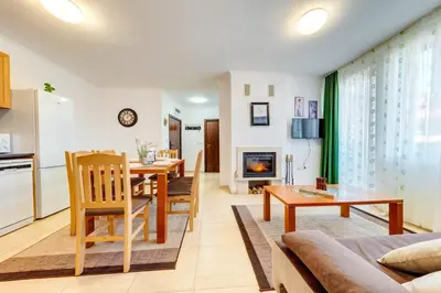a living room with a dining room table and a kitchen at Тристаен апартамент 1А17 Гранд Манастира Пампорово in Pamporovo