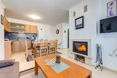 a living room with a table and a fireplace at Тристаен апартамент 1А17 Гранд Манастира Пампорово in Pamporovo