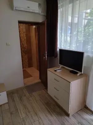 a room with a television on a dresser with a door at Къща за гости Св Никола in Tschepinzi