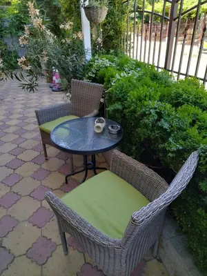a patio with two chairs and a table and a table and chairs at Къща за гости Св Никола in Tschepinzi
