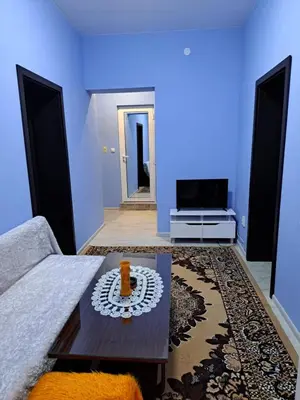 a blue living room with a couch and a table at Асклепион in Kyustendil