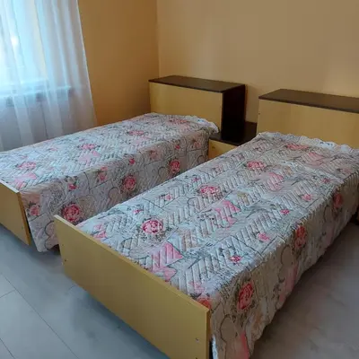 two beds sitting next to each other in a room at Асклепион in Kyustendil