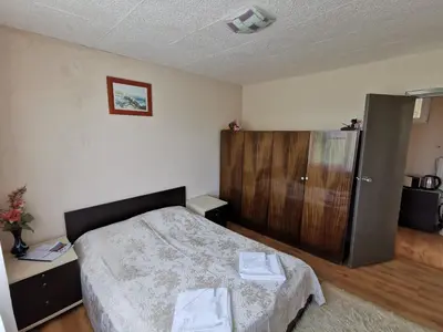 a bedroom with a bed and a wooden cabinet at Villa Aqua in Pravets