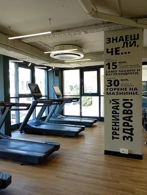a gym with a row of treadles in a room at Light View Apartment - New Center in Sofia
