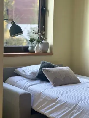 a bed with two pillows and a lamp and a window at Deno Studio in Borovets