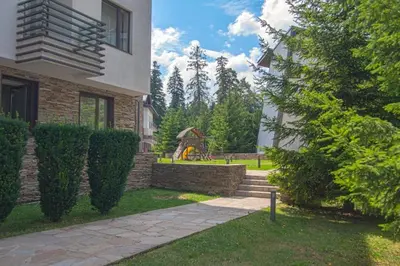 a house with a yard with a playground in the background at Deno Studio in Borovets