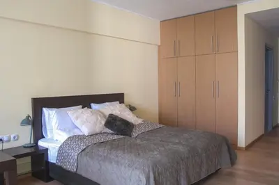 a bedroom with a bed and wooden cabinets at Deno Studio in Borovets