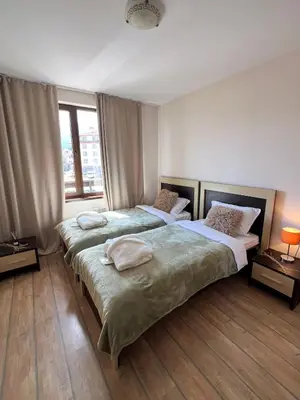 two twin beds in a room with a window at Alpine Lodge Chalet in Bansko in Bansko