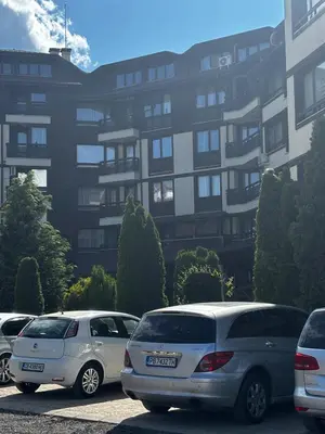 three cars parked in a parking lot in front of a building at Alpine Lodge Chalet in Bansko in Bansko