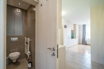 a bathroom with a toilet next to a hallway at SOFIA41 - Prime Location in Sofia