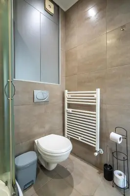a bathroom with a white toilet and a shower at SOFIA41 - Prime Location in Sofia