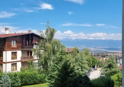 a view of a building with trees and a road at Green Life Private Apartment D25 in Bansko