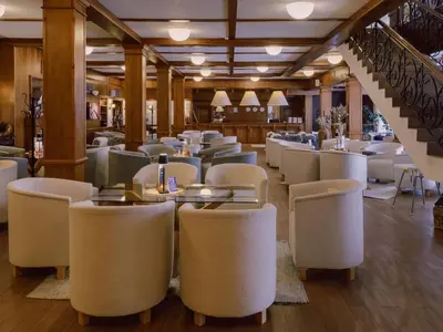 a restaurant with white chairs and tables and a staircase at Green Life Private Apartment D25 in Bansko