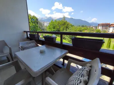 a table and chairs on a balcony with a view at Green Life Private Apartment D25 in Bansko