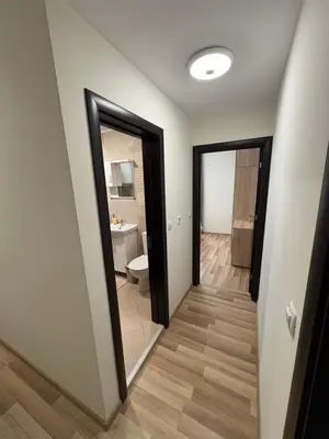 a hallway with a bathroom with a toilet and a mirror at Nikea apart 2 in Velingrad