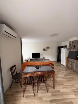 a room with a table and chairs and a kitchen at Nikea apart 2 in Velingrad