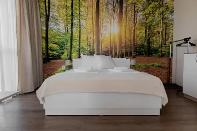 a bedroom with a white bed in the woods at Просторен апартамент за семейна почивка in Hisarya